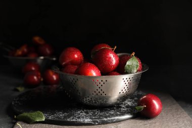 Kolander koyu arkaplanda olgun taze eriklerle