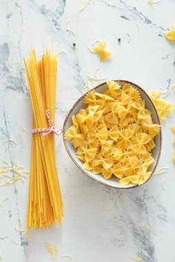 Hafif arka planda pişmemiş makarna ile kase