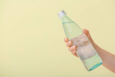 Kadın eli ve arka planda bir şişe su