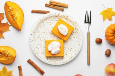 Beyaz arkaplanda lezzetli balkabağı turtası parçalarıyla sonbahar kompozisyonu