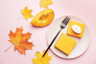 Renkli arkaplanda lezzetli balkabağı turtası olan tabak.