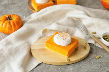 Arkaplanda lezzetli balkabağı turtası olan tahta.