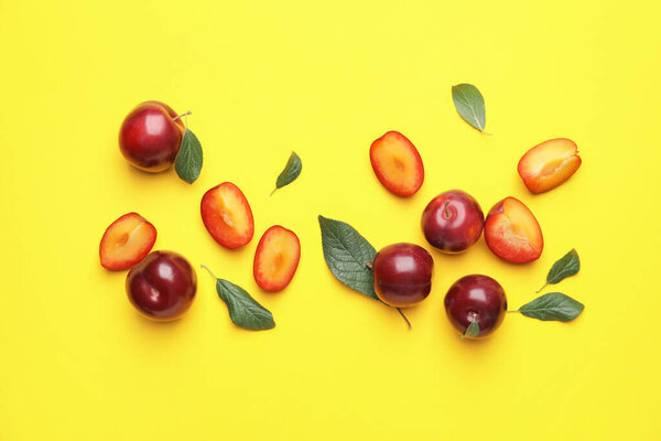 Fresh ripe plums on  color background