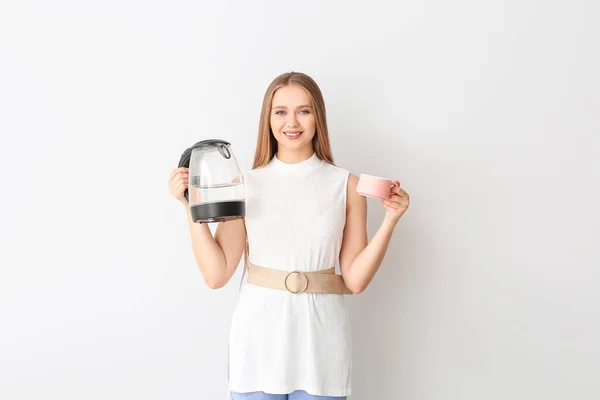 Beyaz Arka Planda Elektrikli Çaydanlık Bardak Tutan Mutlu Kadın — Stok fotoğraf