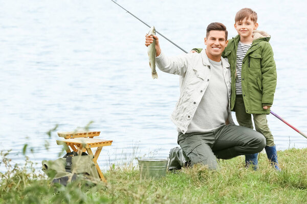 Мальчик и его отец рыбачат на реке