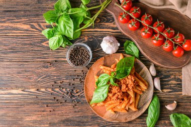 Ahşap zemin üzerinde domates soslu makarna tabağı.