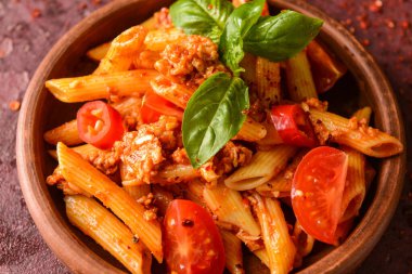 Masada domates soslu makarna kasesi, yakın plan.