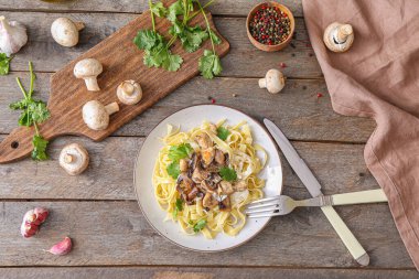 Tahta masada tavuk ve mantarlı bir tabak lezzetli makarna.