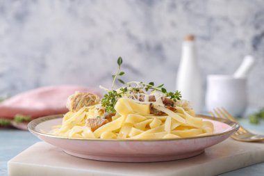 Bir tabak lezzetli makarna, yanında tavuk ve mantar.