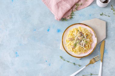 Bir tabak lezzetli makarna, yanında tavuk ve mantar.