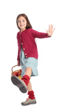 Beyaz arka planda elmalarla dolu sepeti tutan tatlı küçük kız.