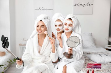 Güzel genç kadınlar şımarık bir partide selfie çekiyorlar.