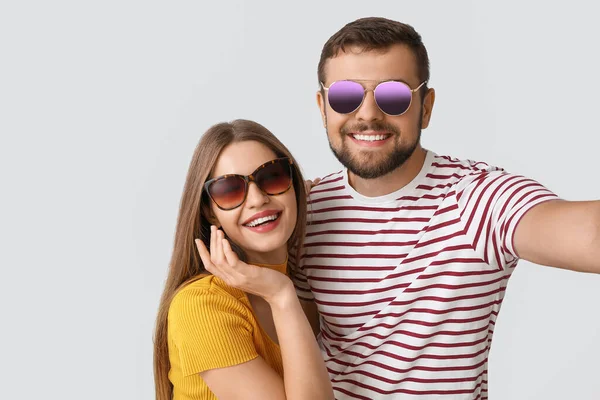 Pareja Joven Con Gafas Sol Elegantes Tomando Selfie Sobre Fondo — Foto de Stock