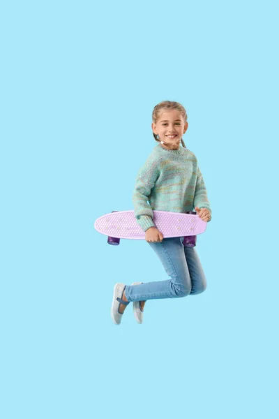 Jumping Liten Flicka Med Skateboard Färg Bakgrund — Stockfoto