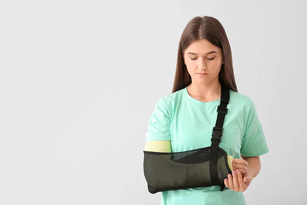 Mujer Joven Con Brazo Roto Sobre Fondo Claro —  Fotos de Stock