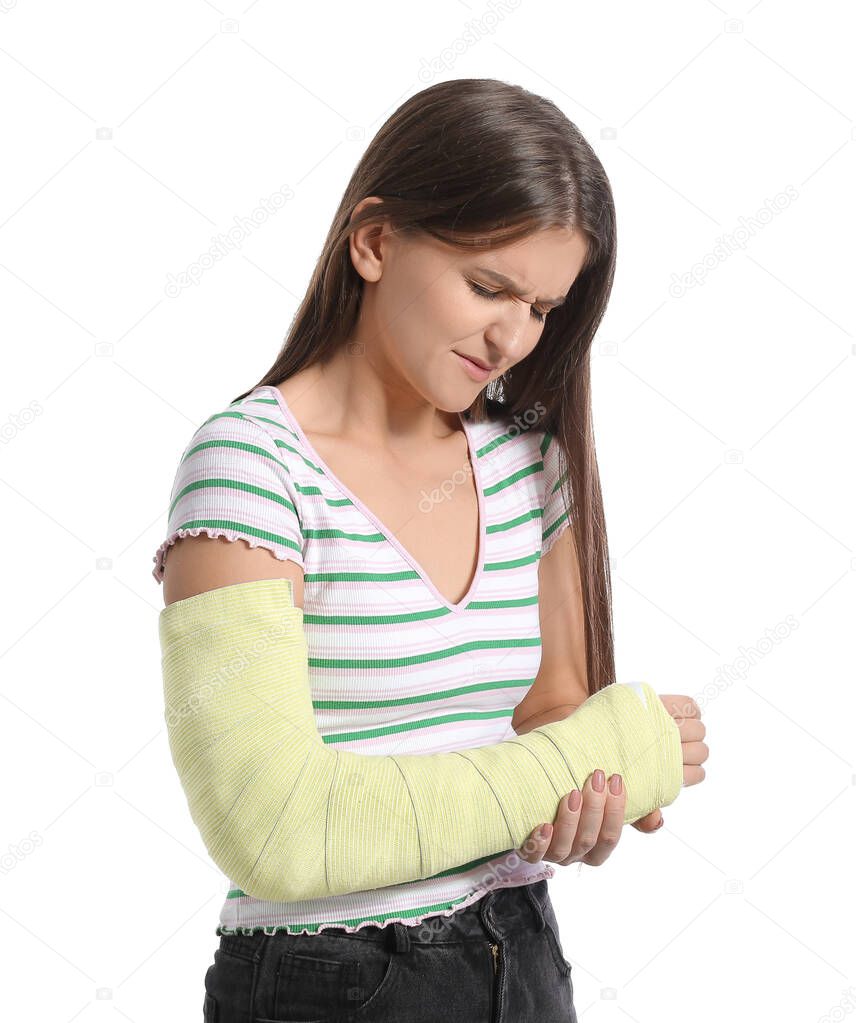 Young woman with broken arm on white background