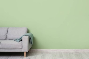 Renkli duvarın yanında ekoseli kanepe.