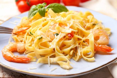 Bir tabak lezzetli makarna ve masada karides.