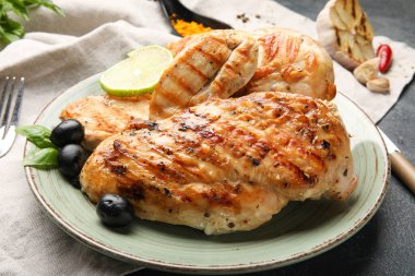 Koyu arkaplanda pişmiş tavuk fileto tabağı.