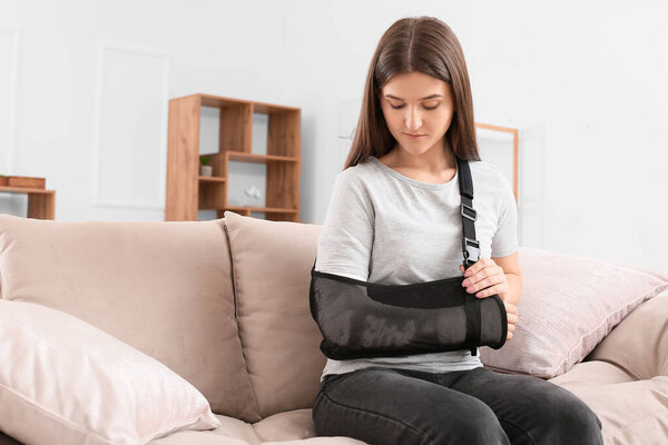 Молодая женщина со сломанной рукой дома