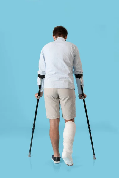 Νεαρός Άνδρας Σπασμένο Πόδι Στο Φόντο Χρώμα — Φωτογραφία Αρχείου