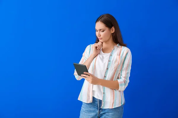 Nachdenkliche Junge Frau Mit Reader Auf Farbigem Hintergrund — Stockfoto