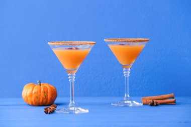 Renkli ahşap arka planda balkabaklı martini bardakları