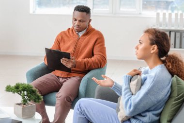 Ofiste Afro-Amerikalı bir kadınla çalışan bir psikolog.