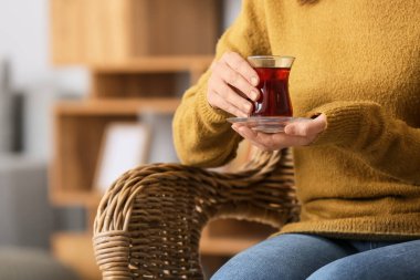 Evde Türk çayı içen genç bir kadın