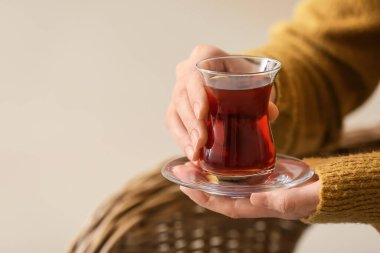 Evde Türk çayı içen genç bir kadın, yakın plan.