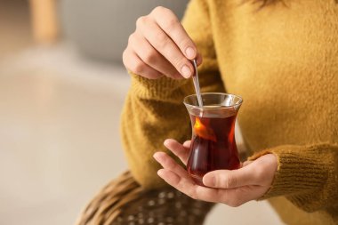 Evde Türk çayı içen genç bir kadın