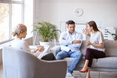 Ofiste genç bir çiftle çalışan psikolog.