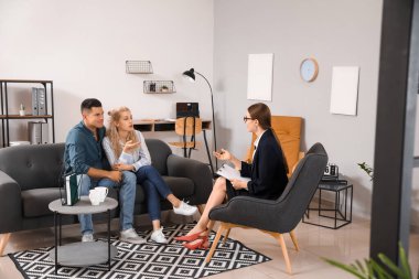 Ofiste genç bir çiftle çalışan psikolog.