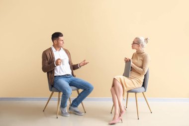 Ofiste genç bir adamla çalışan psikolog.