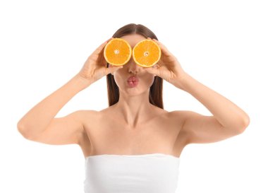 Beyaz arka planda portakal dilimleri olan komik genç bir kadın.