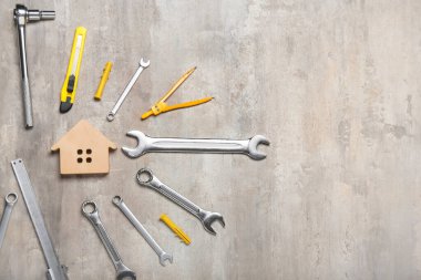 Gri arka planda malzemeleri olan ev modeli