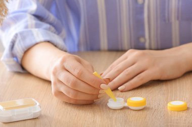 Konteynırdan objektifi alan kadın ahşap masada solüsyonlu