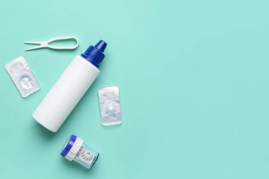 Renk arkaplan üzerinde kontak lens, çözüm ve cımbız içeren konteyner