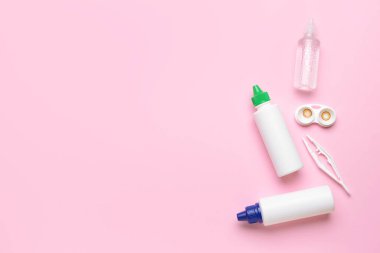 Renk arkaplan üzerinde kontak lens, çözüm ve cımbız içeren konteyner