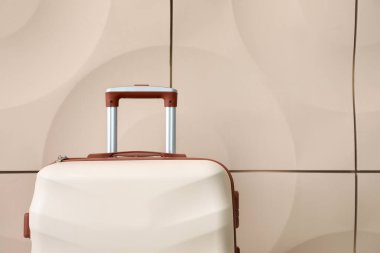 Işık duvarının yanında paketlenmiş bavul