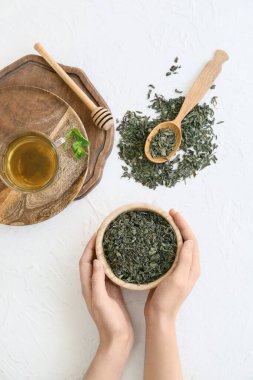 Kuru çay yapraklı kadın ışık masasında kasede