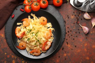 Bir tabak lezzetli makarna ve masada karides.