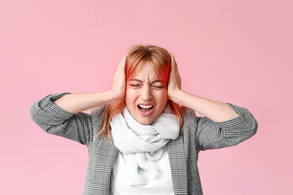 Mature woman suffering from head ache on color background