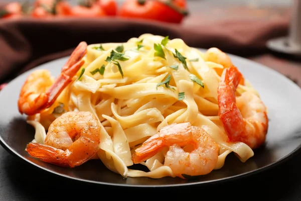 Plate of tasty pasta with shrimps on table