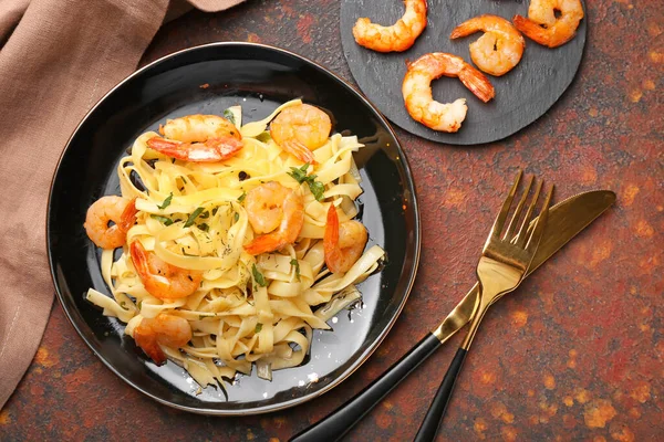 Plate of tasty pasta with shrimps on table