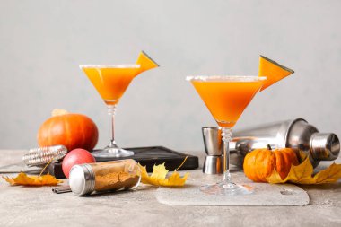 Gri arkaplanda bir bardak lezzetli balkabağı turtası martini.