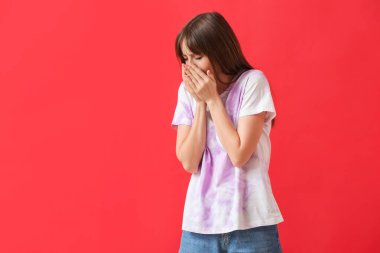 Renkli arka planda öksüren genç kadın