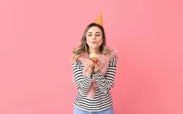 Beautiful Young Woman Blowing Out Candle Birthday Cupcake Color Background — Stock Photo, Image