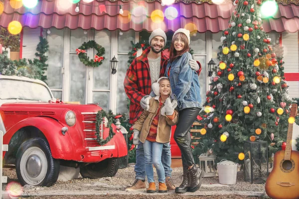 Happy family near house decorated for Christmas