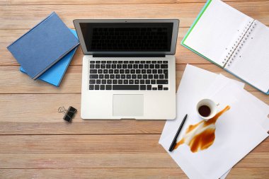 Laptop, kırtasiye ve kahve sehpasına dökülmüş.